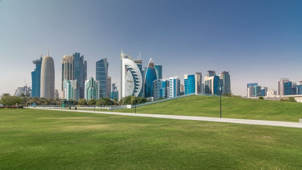 Doha skyline across a green park